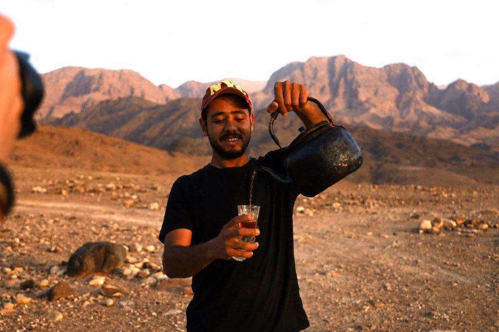 Local guide pouring Bedouin tea in the Jordanian mountains