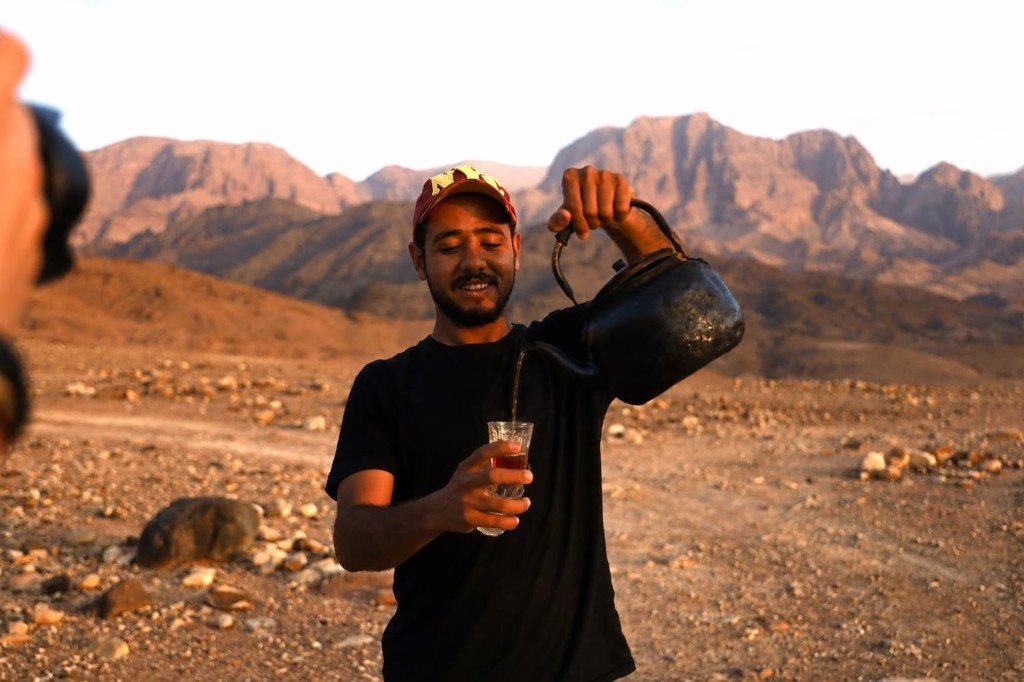 Local guide pouring Bedouin tea on the trail