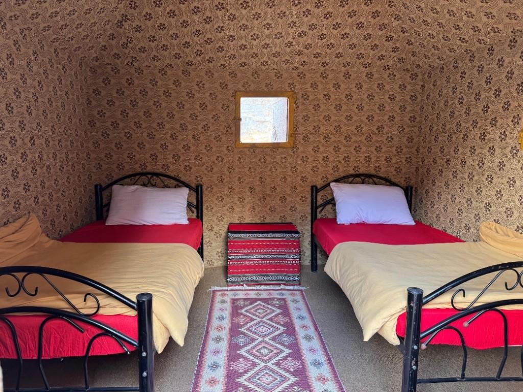 Twin beds inside a traditional fabric-lined camp room