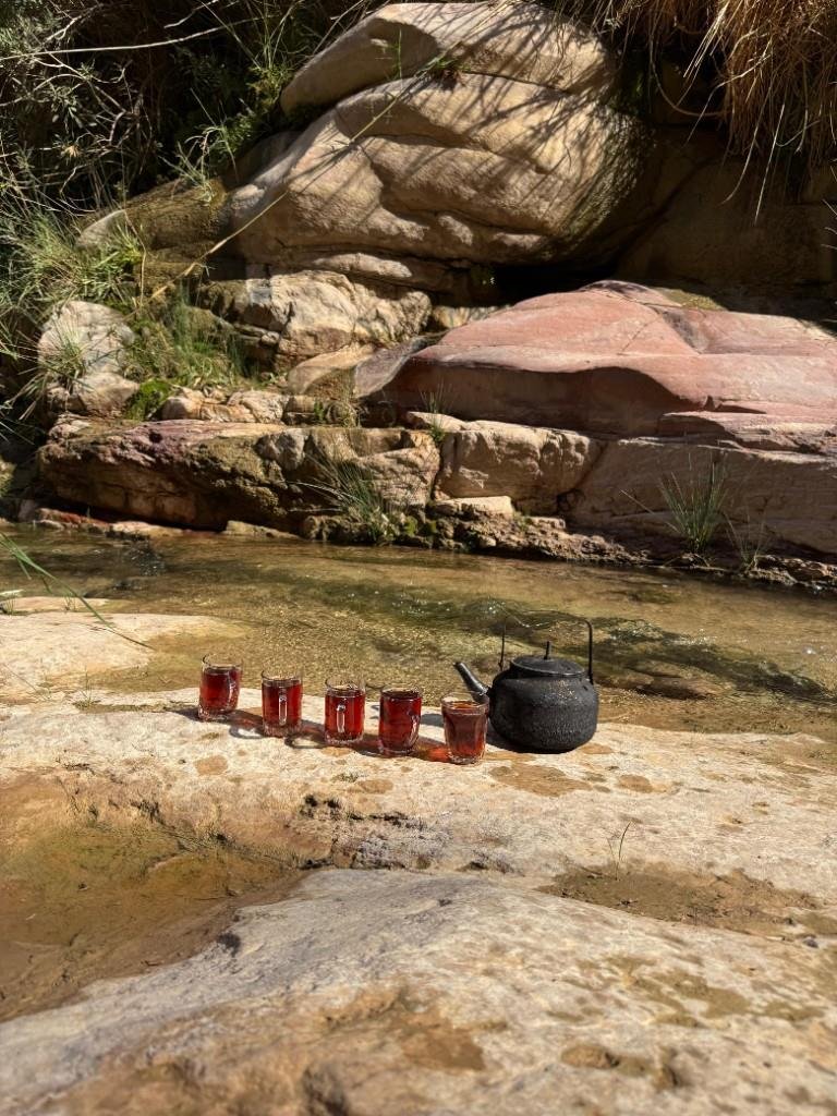 Bedouin tea glasses and kettle by a canyon stream